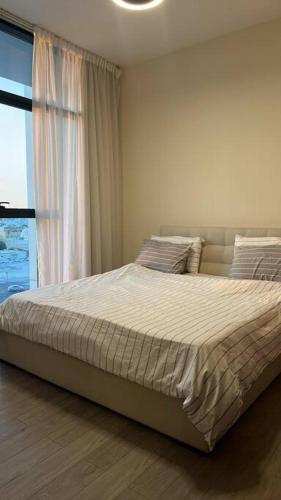 a bedroom with a large bed with a window at Home 4U in Dubai Center in Dubai