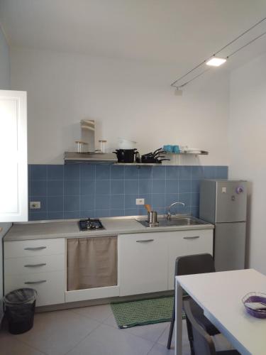 a kitchen with a sink and a refrigerator at LA REGGIA APARTMENTS MILAZZO in Milazzo