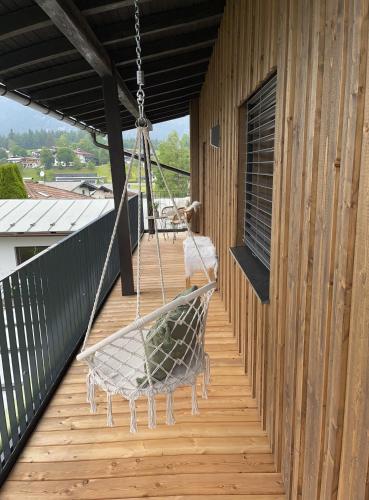 a porch with a hammock hanging from a building at Ferienwohnung Dahoam in Angerberg