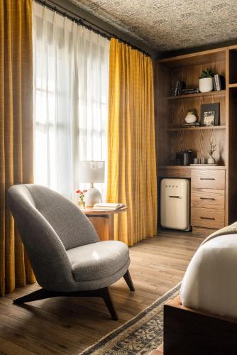 a bedroom with a chair in front of a window at The Richland in Orange