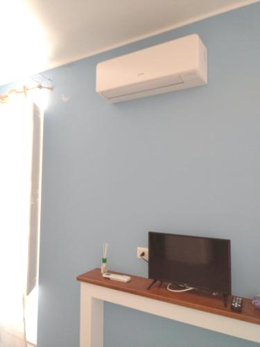 a room with a tv and a ceiling fan at LA REGGIA APARTMENTS MILAZZO in Milazzo