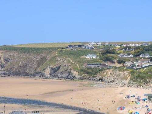 a group of people on a beach with houses at Seaport Lodge in Mawgan Porth