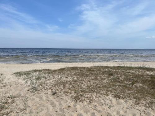 a sandy beach with the ocean in the background at Piejūras apartaments in Ķesterciems