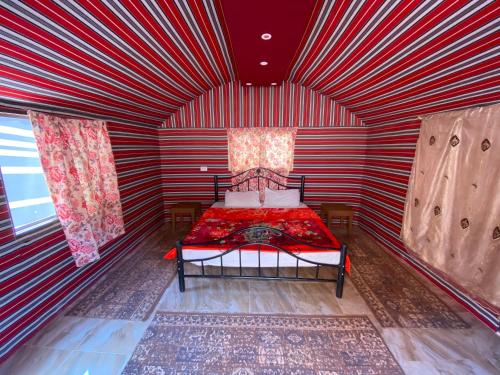 a red and white room with a bed in it at Desert Gate Camp in Wadi Rum