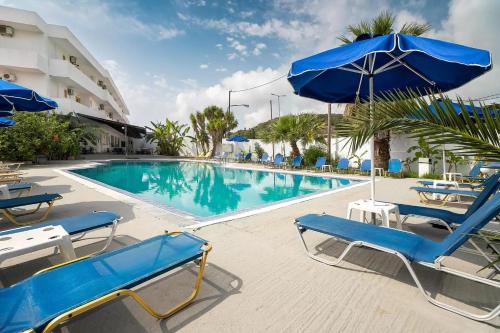 a swimming pool with blue chairs and an umbrella at Sotirakis Hotel in Faliraki