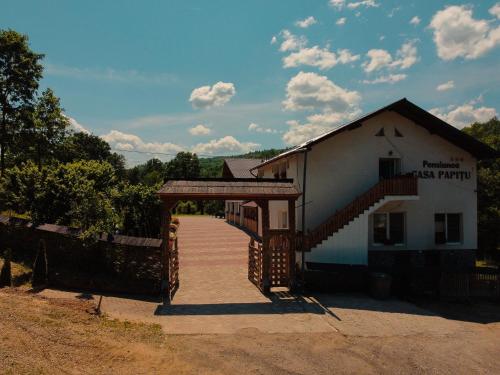 a small building with a wooden walkway next to a building at Casa Papițu in Vadu Izei