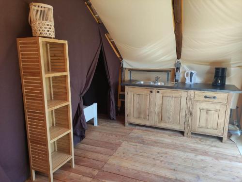 une pièce avec un lavabo et une table dans une tente dans l'établissement Tente Lodge pour 5 personnes en bordure de la rivière Allier au sein d'un petit camping, à Saint-Yorre