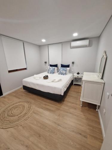 a bedroom with a white bed and a white table at Casa dos Avós - Folgosa Douro in Folgosa