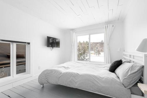 Un pat sau paturi într-o cameră la Nature et tranquilité à une heure de Montréal, vue sur le lac