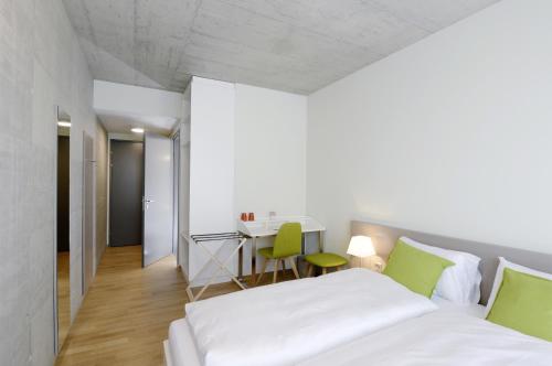 a bedroom with a bed and a desk and a table at Gästehaus Hunziker in Zurich