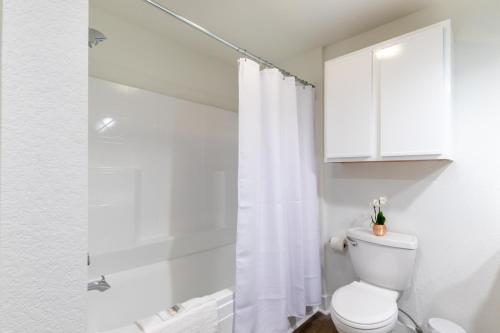 a white bathroom with a toilet and a shower at One Club Gulf Shores in Gulf Shores