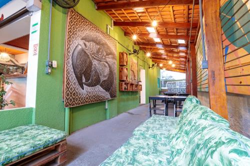Zimmer mit grünen Wänden sowie einem Tisch und Stühlen in der Unterkunft Local Hostel Manaus in Manaus