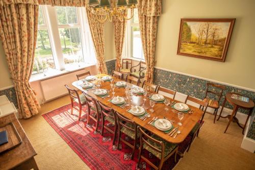 uma sala de jantar com uma mesa longa e cadeiras em Feith Mhor Lodge em Carrbridge