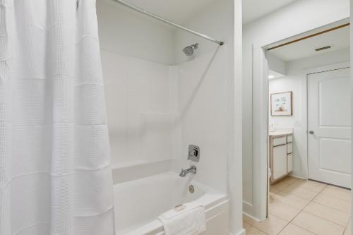 a white bathroom with a tub and a shower curtain at One Club Gulf Shores in Gulf Shores