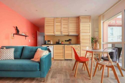 un salon avec un canapé bleu et une table dans l'établissement La Palmeraie - Centre ville & Gare, à Rennes