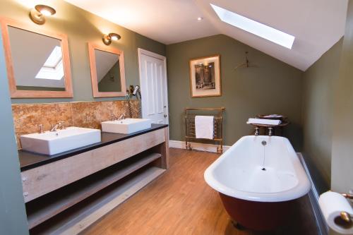 a bathroom with two sinks and a bath tub at Montigo Resorts, Somerset in Shepton Mallet