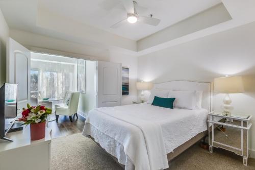 a white bedroom with a bed and a desk at One Club Gulf Shores in Gulf Shores
