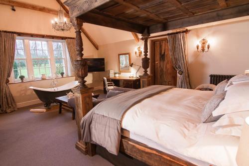 a bedroom with a large bed and a bath tub at Montigo Resorts, Somerset in Shepton Mallet