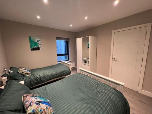 a bedroom with two beds and a closet at seaview 87 in Portrush