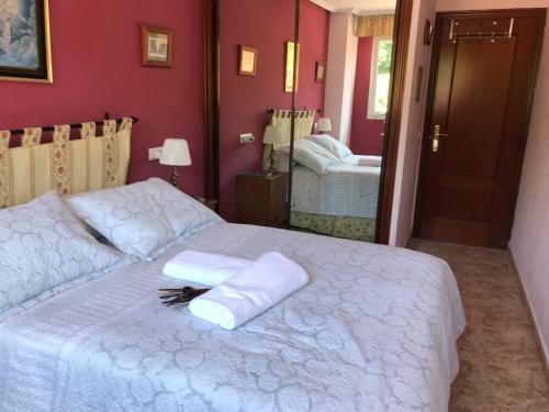 a bedroom with a white bed with two towels on it at APARTAMENTO MEDIODIA in Luanco
