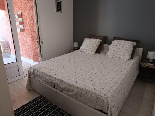 une chambre avec un lit avec des draps blancs et des oreillers dans l'établissement Appartement a 50 mètres de la plage, à Fréjus
