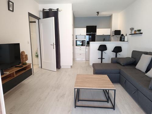 un salon avec un canapé et une table dans l'établissement Appartement a 50 mètres de la plage, à Fréjus