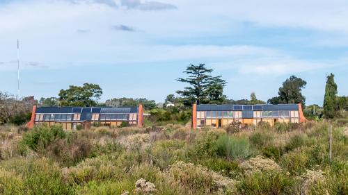 a house with solar panels in a field at Caliu Earthship Ecolodge in Colonia del Sacramento