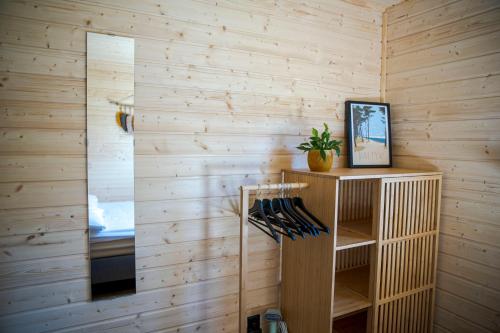 a bathroom with wooden walls and a mirror at WestfalowaChatka domek z jacuzzi in Sasino