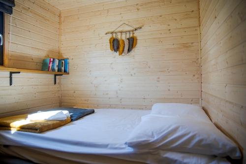 a small room with a bed in a wooden wall at WestfalowaChatka domek z jacuzzi in Sasino