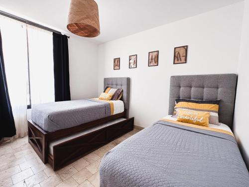a bedroom with two beds and a window at Hermoso depto con alberca en el condo La Luminaria Casonas y Villas in San Miguel de Allende