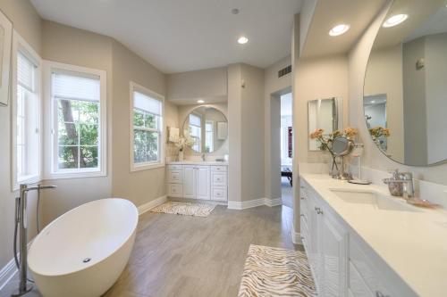łazienka z dużą wanną i dużym lustrem w obiekcie Escape to Luxury Newport Coast Pelican Gated Home w mieście Newport Beach
