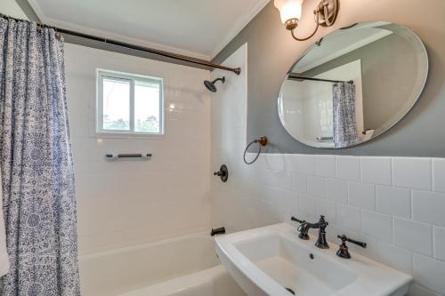 a white bathroom with a sink and a mirror at Cute Downtown Conway Duplex - 15 Mi to Beach! in Conway