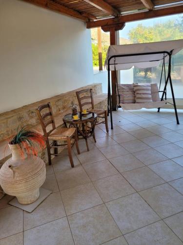 a patio with a table and chairs and a couch at Kouremenos Beach House West in Sitia