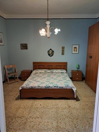 1 dormitorio con cama y lámpara de araña en La casa Dei Dadi en Milazzo