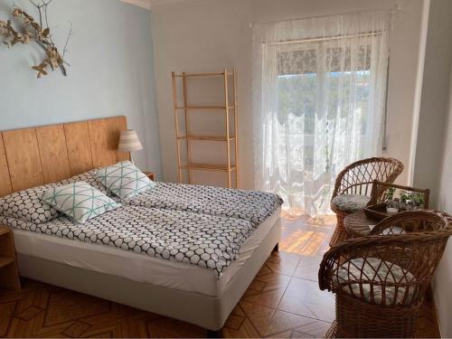 a bedroom with a bed and two chairs and a window at Casa da Rosa in Carvalheira Grande