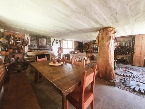 a dining room with a wooden table and a tree at Eco-friendly Guesthouse Tea Gezruli 25 km from Chiatura in Tsinsopʼeli