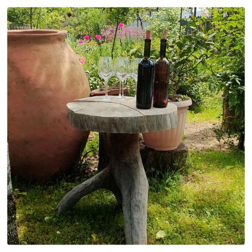 a table with wine bottles and glasses on it at Eco-friendly Guesthouse Tea Gezruli 25 km from Chiatura in Tsinsopʼeli