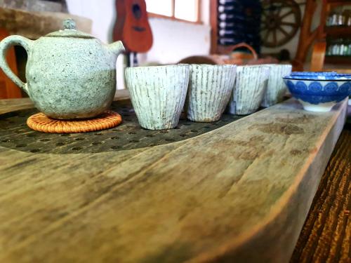 a row of white cups sitting on a wooden table at Eco-friendly Guesthouse Tea Gezruli 25 km from Chiatura in Tsinsopʼeli