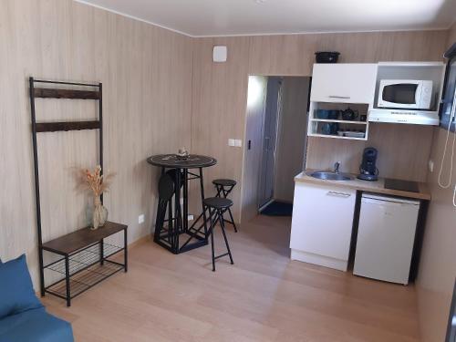 eine kleine Küche mit einem kleinen Tisch in einem Zimmer in der Unterkunft Studio en bois à 20mn du Puy du Fou avec grand jardin in Saint-Mesmin
