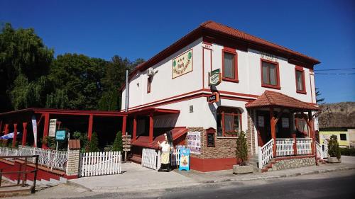 un bâtiment blanc et rouge avec un gambrel dans l'établissement Park Hédervár, à Hédervár