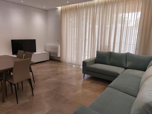 a living room with a couch and a table at Illyrian Elite Gjiri i Lalezit in Durrës