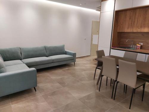 a living room with a couch and a table and chairs at Illyrian Elite Gjiri i Lalezit in Durrës