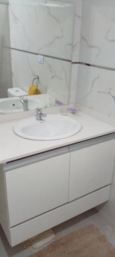 une salle de bain blanche avec un lavabo et un miroir dans l'établissement Das thomy, à Córdoba