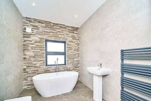 Ένα μπάνιο στο Spacious 4BR House, London, Sleeps 9, Parking Available