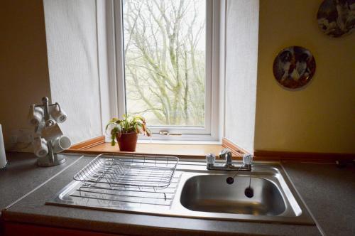 eine Küche mit einem Waschbecken und einem Fenster in der Unterkunft Keepers in Alston