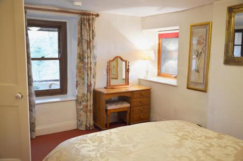 ein Schlafzimmer mit einem Bett, einem Spiegel und einer Kommode in der Unterkunft Keepers in Alston