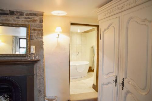 een badkamer met een open haard en een badkamer met een bad bij Bothy in Alston