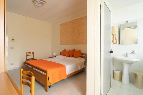 1 dormitorio con cama con almohadas de color naranja y lavamanos en Hotel La Fonte a 300m uscita A14 Pescara Nord, en Citta' Sant'Angelo