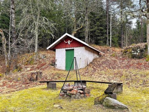 a smallshed with a green door on a hill at 6 person holiday home in SANDHULT-By Traum in Sandhult
