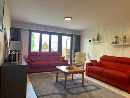a living room with two red couches and a table at Appartement Haute-Nendaz in Nendaz